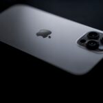 Close-up shot of a sleek smartphone showcasing triple camera lenses on a dark background.