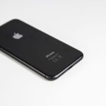 Black smartphone placed on a clean white surface, highlighting modern design and tech elegance.