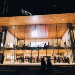 Vibrant night scene of an Apple Store in Vancouver, highlighting modern architecture and urban lifestyle.