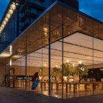 Stunning view of a modern glass building exterior illuminated at night.