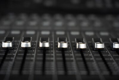 Detailed view of audio mixer faders, essential tool for sound engineering in studios.